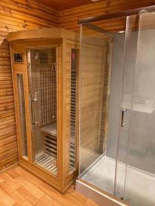 ArthonRomantique chalet avec sauna et jacuzzi extérieur的木墙客房中的步入式淋浴间