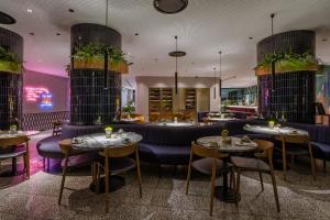 里斯本Hotel Hotel - Member of Design Hotels的餐厅配有紫色家具和桌椅