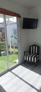 阿德耶Asociación deportiva TAGOROR LOS OLIVITOS的带沙发和滑动玻璃门的客厅