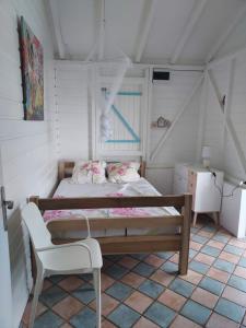 拉特里尼泰la villa caribéenne de la plage des surfeurs的一间小卧室,配有一张床和一把椅子