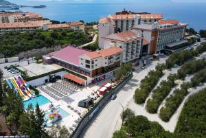 库萨达斯Ramada Hotel & Suites by Wyndham Kusadasi的享有带游泳池的度假村的空中景致