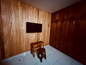 戴维Residencial Coya的客房设有木墙、桌子和电视。