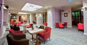 波亚纳布拉索夫Apartament 508-Aparthotel Alpin Poiana Brasov- acces la piscină gratuit的一间餐厅,房间内设有红色的椅子和桌子