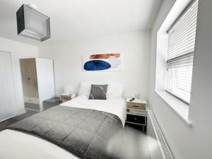 浦耳Anchorage的一间白色卧室,配有床和电视