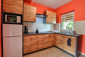 下乌斯奇基Domek Limba的厨房配有木制橱柜和白色冰箱。