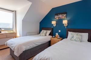 阿勒浦Lochbroom Lodge的一间卧室设有两张床和蓝色的墙壁