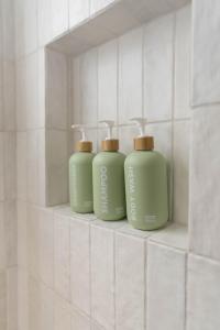 圣地亚哥The Laurel Loft的浴室内置在架子上的三瓶绿瓶