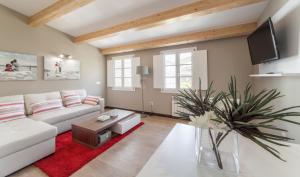 圣地亚哥－德孔波斯特拉Nova Compostela Apartments的客厅配有白色沙发和红色地毯。