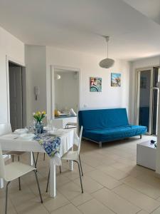 马尔扎梅米Casa Vacanze Matilde Marzamemi的客厅配有桌子和蓝色沙发