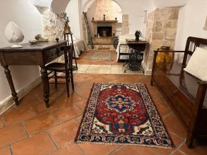 奥斯图尼Trulli Santa Maria Odegitria Relais的客厅配有桌子和地毯。