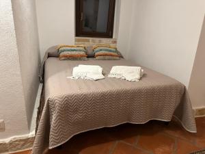 奥斯图尼Trulli Santa Maria Odegitria Relais的一张床上有两个枕头的房间