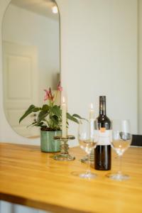 库雷萨雷Luxury apartment close to the sea的一张桌子,上面放有两瓶葡萄酒和眼镜