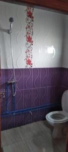 Tan-Tan PlageAppart avec terrasse El Ouatia Tan Tan Plage的浴室设有卫生间,铺有紫色和白色瓷砖。