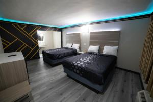 贝尔弗劳尔Artesia Motor Inn的酒店客房,设有两张床和一张沙发