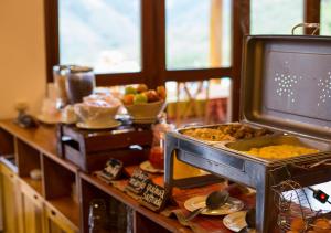 CocachimbaGocta Andes Lodge的厨房配有带食物的桌子和电视。