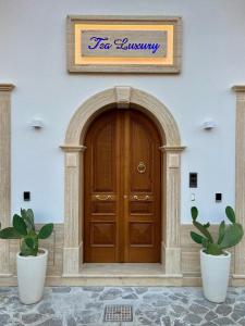 普拉亚·阿马勒TEA Luxury - Praia a Mare的两棵盆栽植物的楼房中的木门