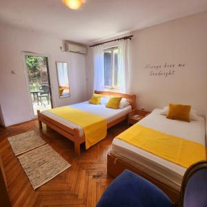 拉法洛维奇A step to the sea-Na korak do mora-Studio apartments Bela kuća的客房设有两张带黄床单的床和窗户。