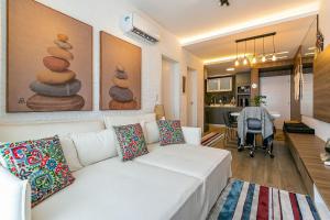 弗洛里亚诺波利斯Apto no cond Thai Beach Home Spa frente mar TBS106的一间带白色沙发的客厅和一间厨房