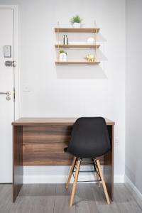 圣海伦斯Stylish Studios with Ensuite, Separate Kitchen, and Prime Location in St Helen的一张黑椅子,坐在一张木桌子前