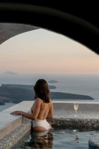 易莫洛林文图斯天堂别墅的坐在游泳池里喝一杯葡萄酒的女人