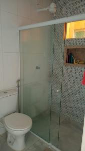加拉尼温斯Casa Duplex - Garanhuns的一间带卫生间和玻璃淋浴间的浴室
