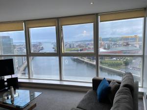 贝尔法斯特Titanic and Sea View Belfast 2 bedroom Apartment City Centre的客厅设有大窗户,享有河景