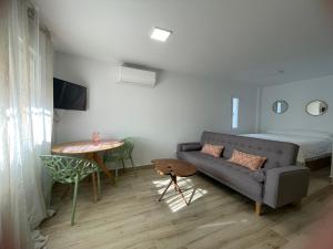 韦尔瓦Apartamento turístico Ático La Piterilla的客厅配有沙发、桌子和床。