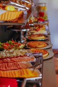 坎波斯杜若尔当普萨大康斯特雷甚旅舍的包含许多不同类型的比萨饼的自助餐