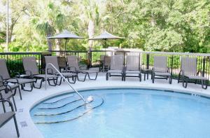 费南迪纳比奇艾米丽亚岛希尔顿恒庭酒店的一个带椅子的游泳池以及一个喷泉