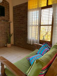 戈多伊克鲁斯Departamento Privado para dos personas en Mendoza的客厅设有绿色沙发和窗户。