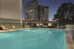 亚特兰大亚特兰大-巴克海特汉普顿酒店的一座大型游泳池,其背景是城市天际线