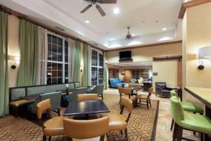 奥斯汀汉普顿酒店-奥斯汀机场的酒店大堂设有桌椅和酒吧