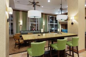奥斯汀汉普顿酒店-奥斯汀机场的一间带桌子和绿色椅子的用餐室