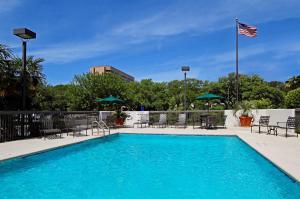 奥斯汀Hampton by Hilton Austin South - I-35 & Ben White的一个带椅子和美洲旗的游泳池