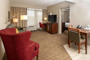 纳什维尔纳什维尔青山汉普顿酒店及套房的酒店客房配有书桌和红色椅子