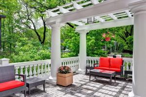 阿灵顿Homewood Suites by Hilton Boston Cambridge-Arlington, MA的庭院上带红色椅子的白色凉亭