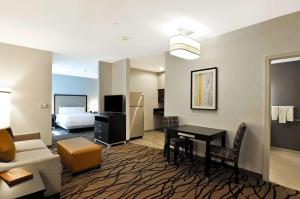 阿灵顿Homewood Suites by Hilton Boston Cambridge-Arlington, MA的酒店客房配有书桌,客房则配有床