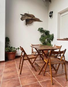 阿兰赫El Balcón de Alange的木桌和椅子,墙上有鱼
