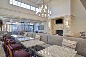 皮博迪Homewood Suites Boston Peabody的餐厅配有沙发、桌子和壁炉