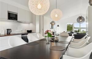 Kisserup3 Bedroom Awesome Home In Holbk的厨房以及带桌椅的用餐室。