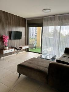 巴特亚姆Green Paradise的客厅配有床、电视和沙发。
