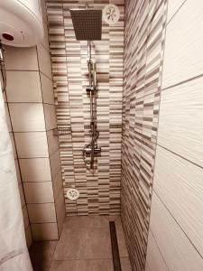 路次亚Lea apartment的浴室铺有白色瓷砖,设有步入式淋浴间。