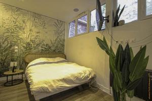 鲁昂CosyRouen Bali Spa Hamman的一间卧室,里面装有床和植物