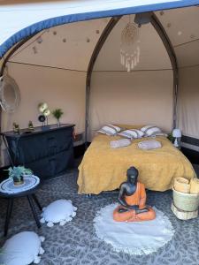 罗斯诺夫·波德·拉德霍斯滕Glamping Rožnov的一间房间,床上有一个僧侣坐在地板上