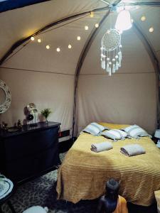 罗斯诺夫·波德·拉德霍斯滕Glamping Rožnov的配有吊灯的帐篷内一间卧室,配有一张床