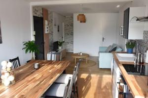 马恩河畔的尚格尼Appartement 4 Chambres的厨房以及带木制餐桌的起居室。