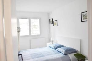 马恩河畔的尚格尼Appartement 4 Chambres的白色的卧室设有床和窗户