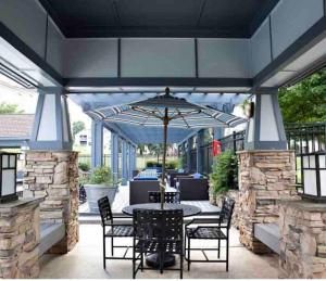 格林斯伯勒King Beds 2- Smart TVs-Free Parking-Patio的庭院配有桌椅和遮阳伞。