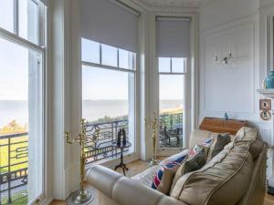 KentWalpole View - Balcony Apartment - Stunning Seafront Views -TV over bath -2mins beach的带沙发和大窗户的客厅