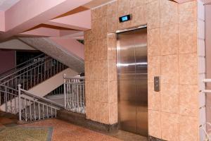 EmbuModern & Homely Suite with Free Parking & WiFi的楼梯楼里的金属电梯
